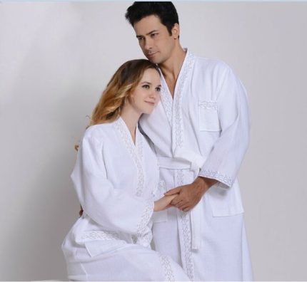 Pareja con batas de felpa blancas de calidad hotelera